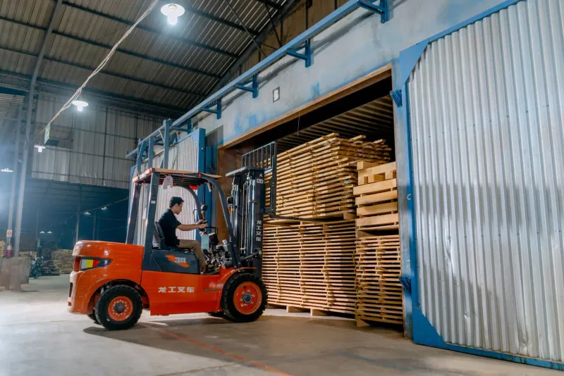 Montacargas moviendo madera aserrada en bodega industrial